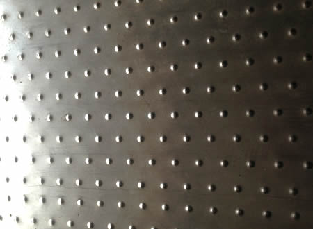 A piece of stainless steel checker plate with small round projections.